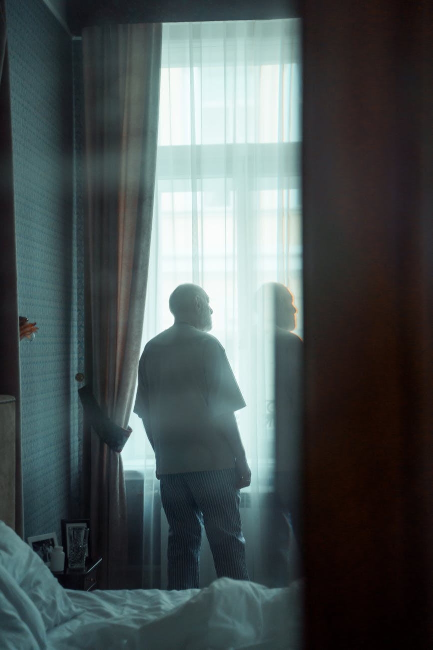 Silhouette of a man in a focused, calm pose against a soft mint-colored light.